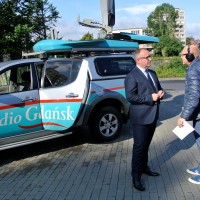 Wóz satelitarny Radia Gdańsk, na jego tle Maciej Kazienko - prezes WFOŚiGW w Gdańsku oraz redaktor Włodzimierz Raszkiewicz